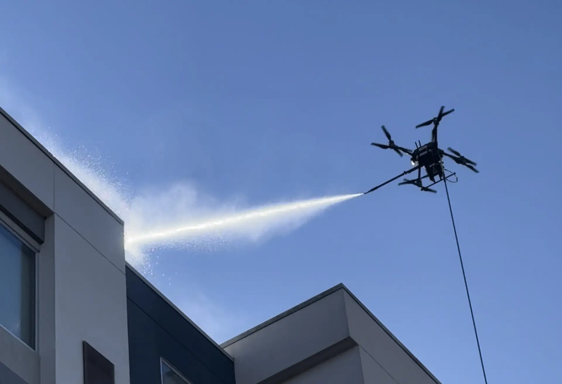 An Aspira AC4 Wash Drone cleaning a building at height